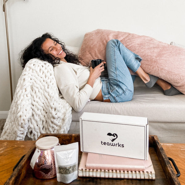 girl relaxing on the couch enjoying her green tea subscription box with organic green loose leaf tea